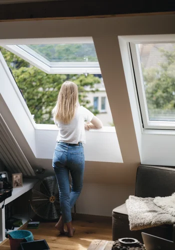 Femme-regardant-fenêtre-velux-ciel-auvergne